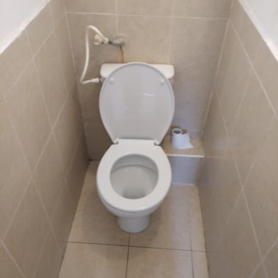 אסלה עם צינור מים מחובר לקיר