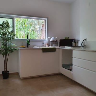 מטבח משופץ עם ארונות לבנים וכיור חדש