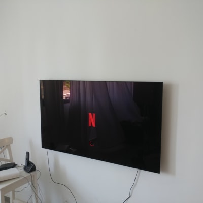 טלוויזיה תלויה על קיר עם כבלים חשופים