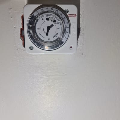 טיימר חשמלי עם חוגה על קיר לבן