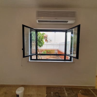 חלון אלומיניום פתוח עם מסגרת שחורה