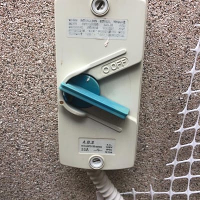 מתג חשמלי עם ידית כחולה על קיר