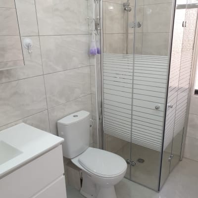 מקלחון זכוכית, אסלה וכיור בחדר אמבטיה מודרני