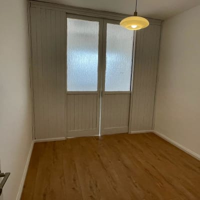 חדר ריק עם רצפת עץ ודלתות זכוכית