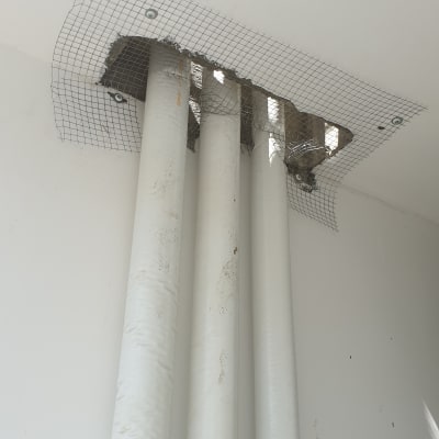 רשת מתכת מותקנת סביב צינורות בתקרה