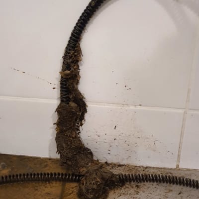 נחשול אינסטלציה מלוכלך עם לכלוך על הרצפה