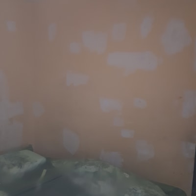 קיר עם תיקוני צבע לבנים על רקע כתום