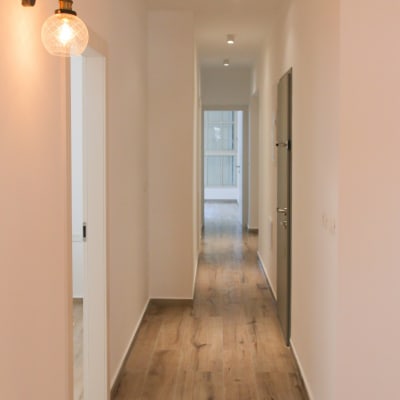 מסדרון עם רצפת עץ חדשה ותאורה מודרנית