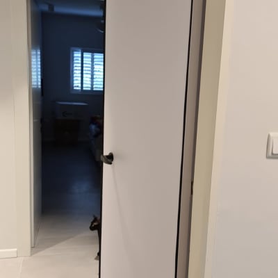 דלת לבנה עם ידית שחורה פתוחה למחצה