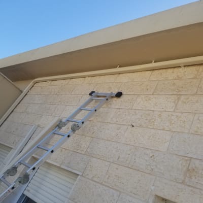 סולם מונח על קיר מתחת לגג