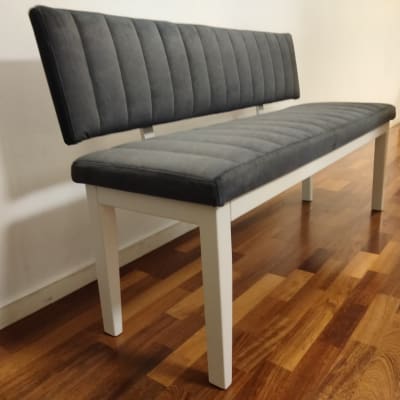 ספסל עץ עם ריפוד אפור על רצפת עץ