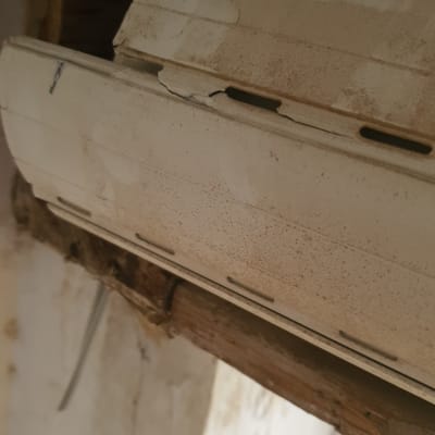 תריס גלילה לבן עם סימני לכלוך ושחיקה