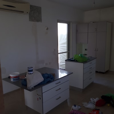 פחיות צבע ומברשת על שולחן במטבח