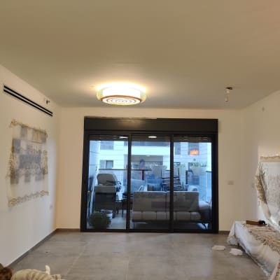 מנורה עגולה מותקנת בתקרה, נורה חשופה ליד.