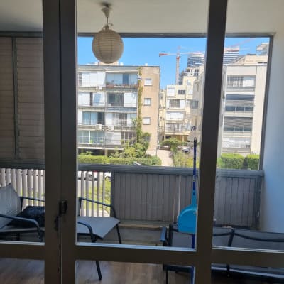 דלת זכוכית עם נוף למרפסת ובניינים