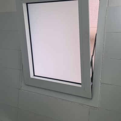 חלון אלומיניום עם מסגרת אפורה על קיר לבן