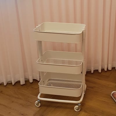 עגלה לבנה עם שלושה מדפים על גלגלים