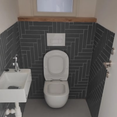 אסלה וכיור בחדר שירותים עם אריחים כהים