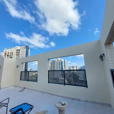 קירות צבועים בצבע בהיר עם פחיות צבע על הרצפה