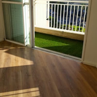 רצפת פרקט עץ בחדר מואר עם מרפסת