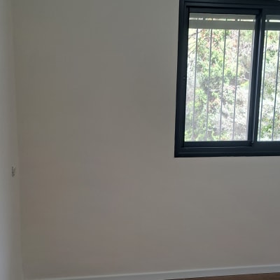 קיר צבוע בלבן עם חלון מסורג