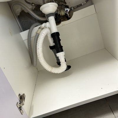 כיור עם צינורות ניקוז מתחת לארון מטבח