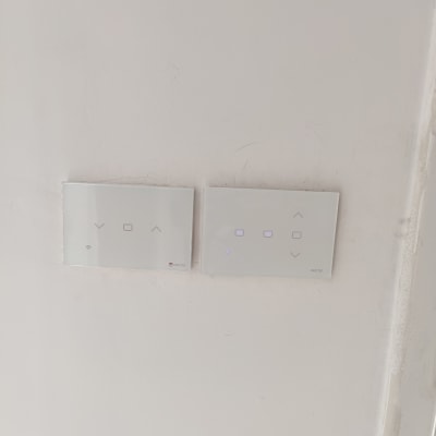 שני מתגי חשמל חכמים על קיר לבן