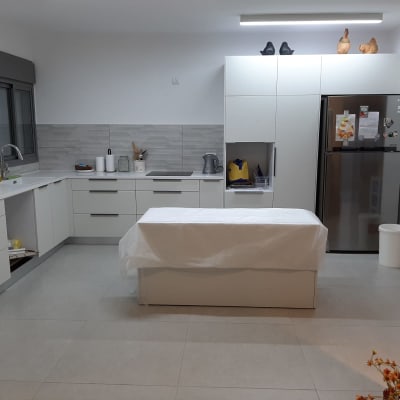 מטבח מודרני עם ארונות לבנים ומקרר נירוסטה