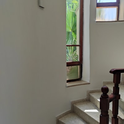 קיר צבוע בלבן ליד חלון ומדרגות