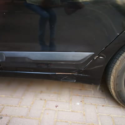 שריטות ופגמים בצבע על דלת רכב שחורה