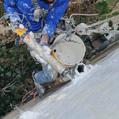 אדם עם קסדה ורובה איטום על קיר