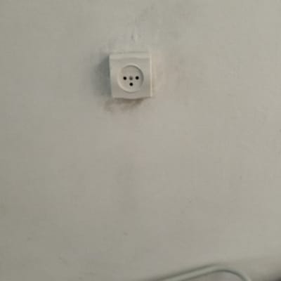 שקע חשמל על קיר לבן עם סימני לכלוך