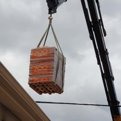 מנוף מרים חבילת רעפים לגג בניין