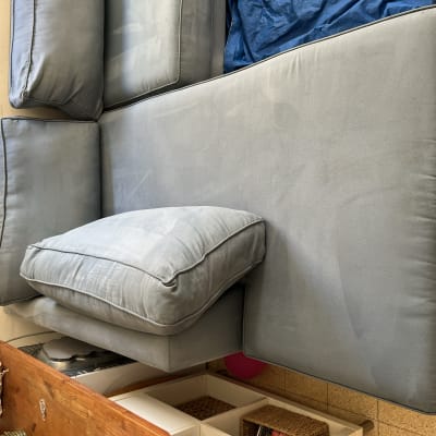 ספה כחולה עם כריות על רצפה מרוצפת