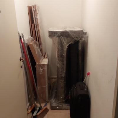 מטאטאים וקרשים עטופים בפלסטיק בחדר קטן