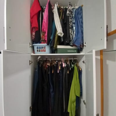ארון בגדים עם בגדים תלויים וסל כביסה