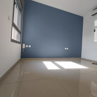 קיר צבוע בכחול בחדר ריק עם חלון