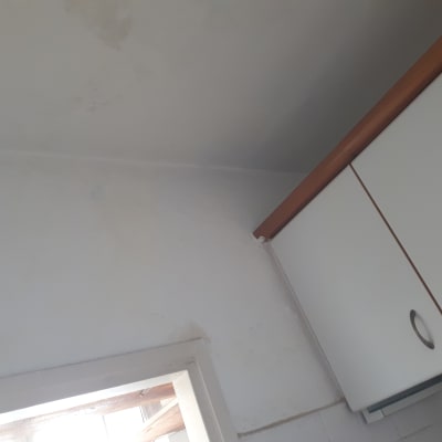 קיר לבן עם סימני רטיבות ותקרה צבועה