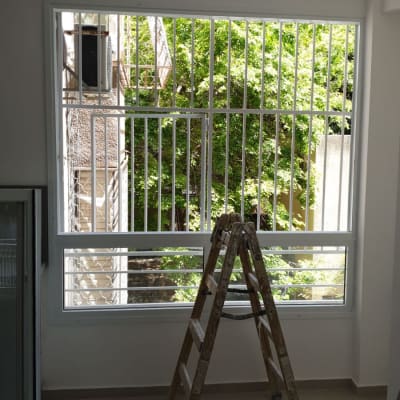 חלון עם סורגים וסולם עץ בחדר
