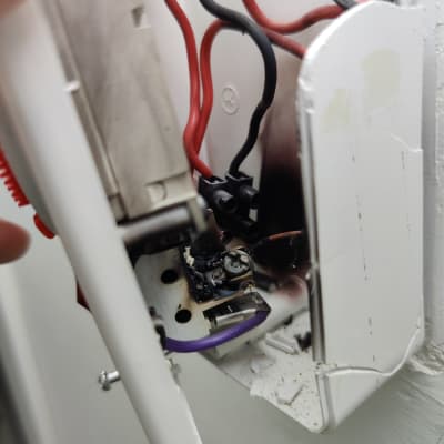 חוטי חשמל אדומים ושחורים בתוך קופסת חיבורים