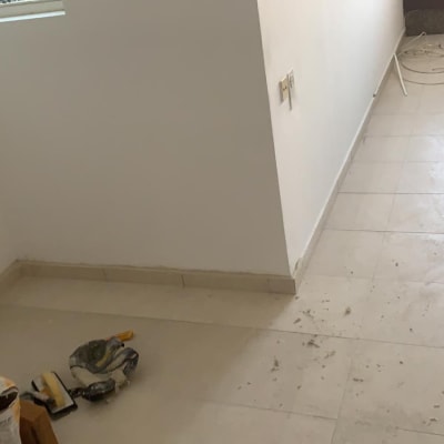 שק מלט, כפפות וכלי עבודה על רצפה