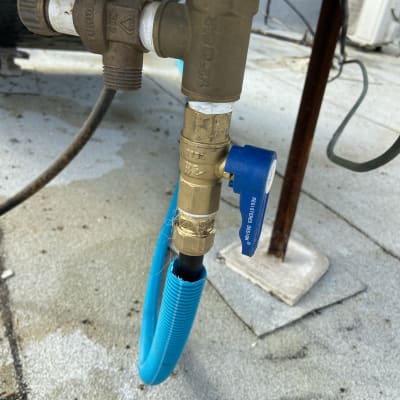 צינור כחול מחובר לשסתום מתכת עם ברז