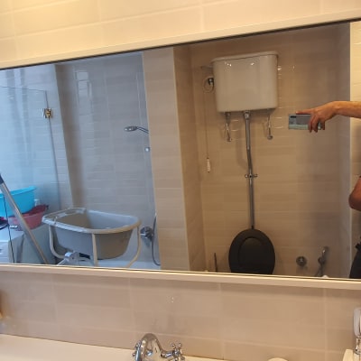 מראה גדולה בחדר אמבטיה עם השתקפות של אדם