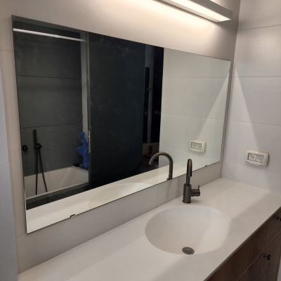 מראה גדולה מעל כיור בחדר אמבטיה מודרני