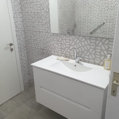 כיור לבן עם ברז, אריחים גיאומטריים על הקיר