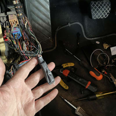 יד מחזיקה חוטים חשמליים ברכב עם כלים מסביב