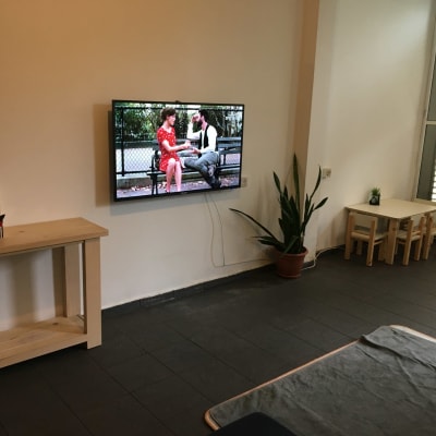 טלוויזיה תלויה על הקיר עם כבלים גלויים