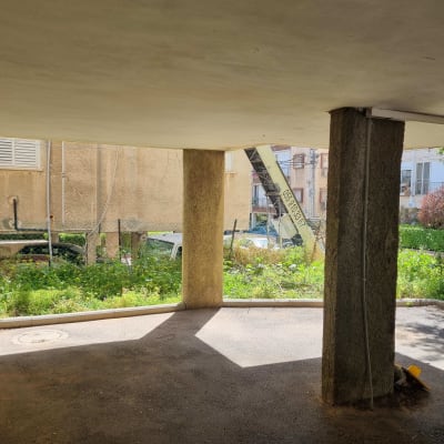 מנוף צהוב עם זרוע מורמת בחצר בניין