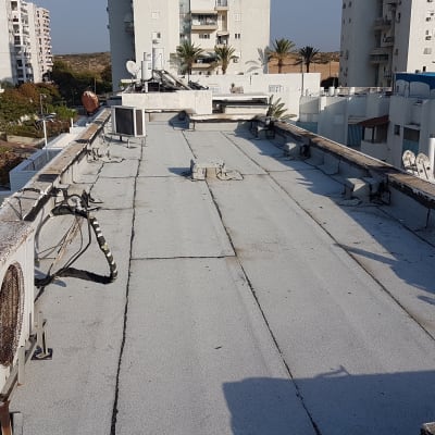 גג עם יריעות איטום, מזגן וצינורות חשופים