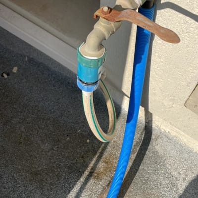 ברז מים עם צינור כחול מחובר לקיר